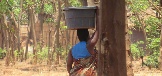 Woman carrying water bucket on her head